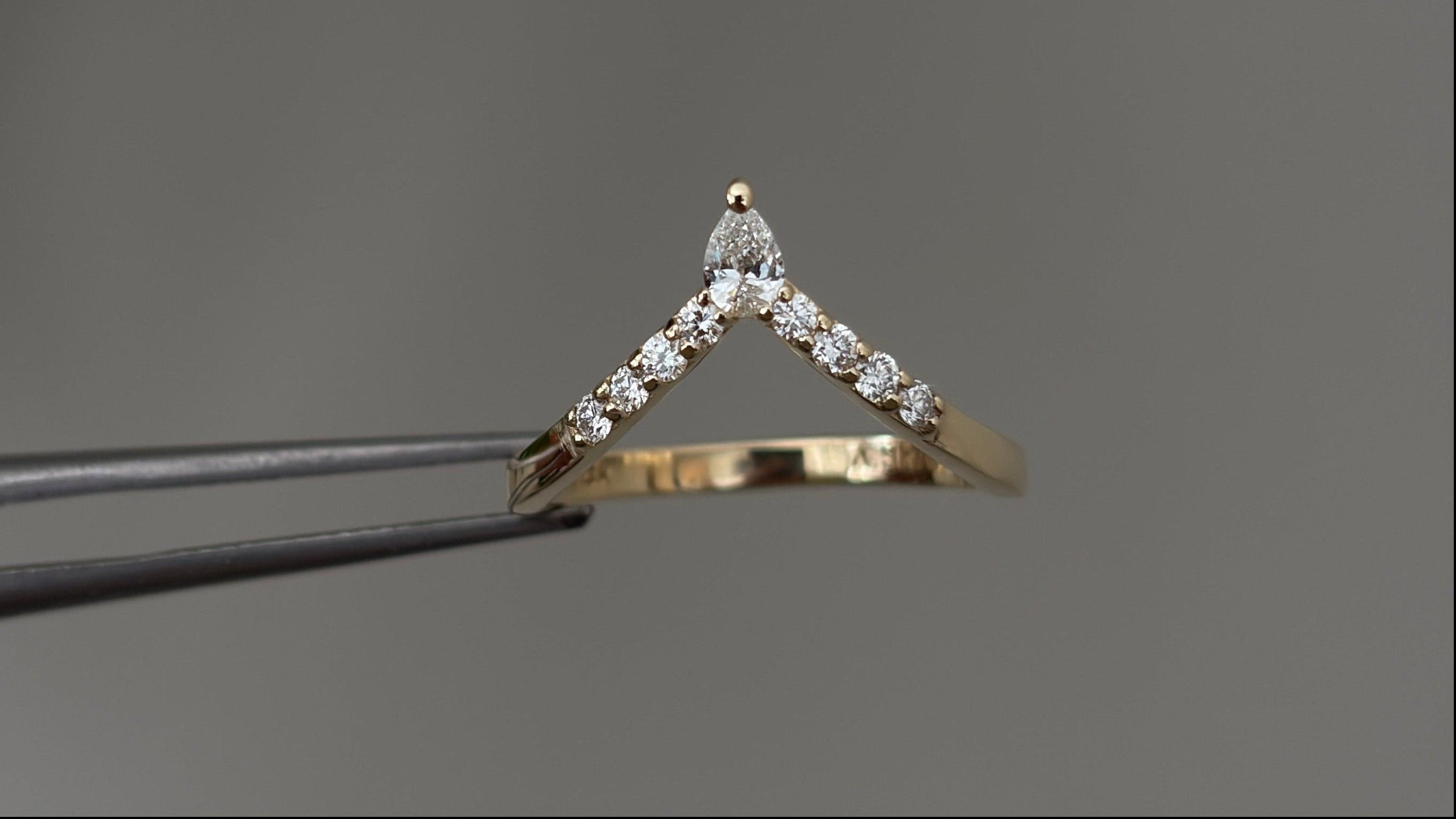 Gold diamond ring on a gray background