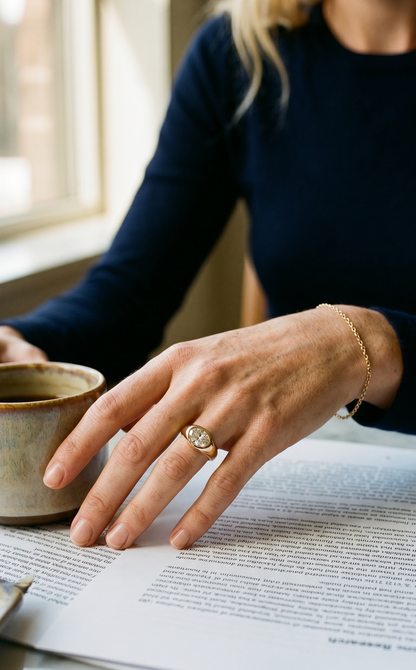Person holding a mug with a document open on a table