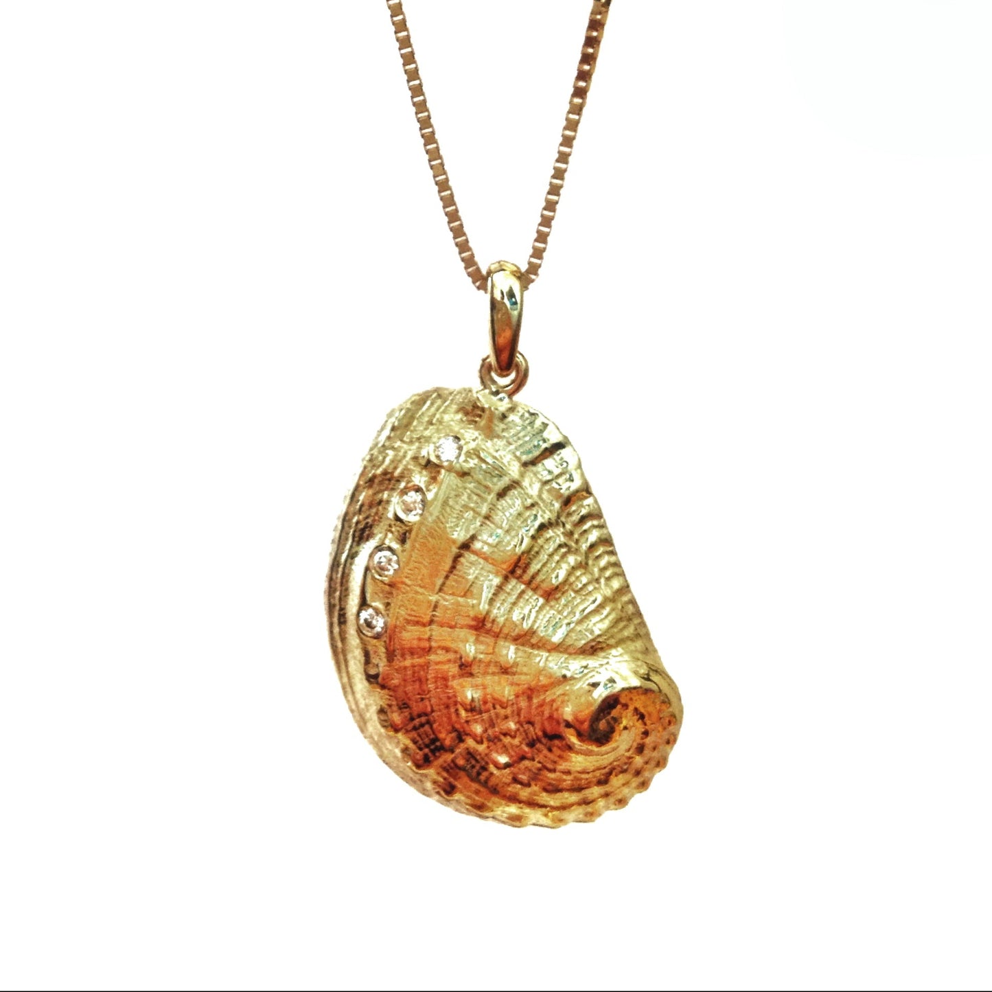 A gold seashell pendant necklace with diamonds displayed against a white background.