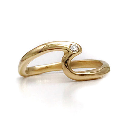 A 14k gold solid wave-shaped ring with a single white diamond stone set in the center, displayed on a white background.