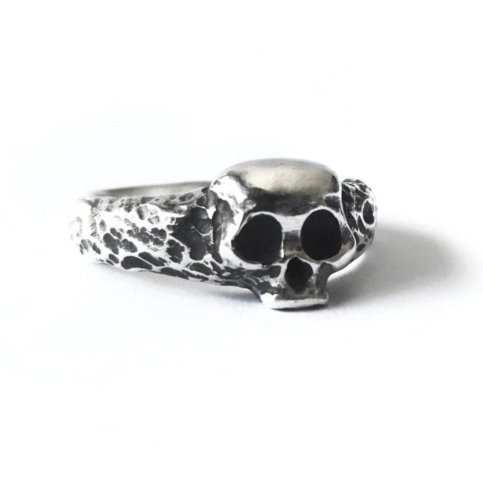 A realistic skull ring made of solid 925 sterling silver, featuring a detailed design with a rustic feel and a glossy silver shimmer.