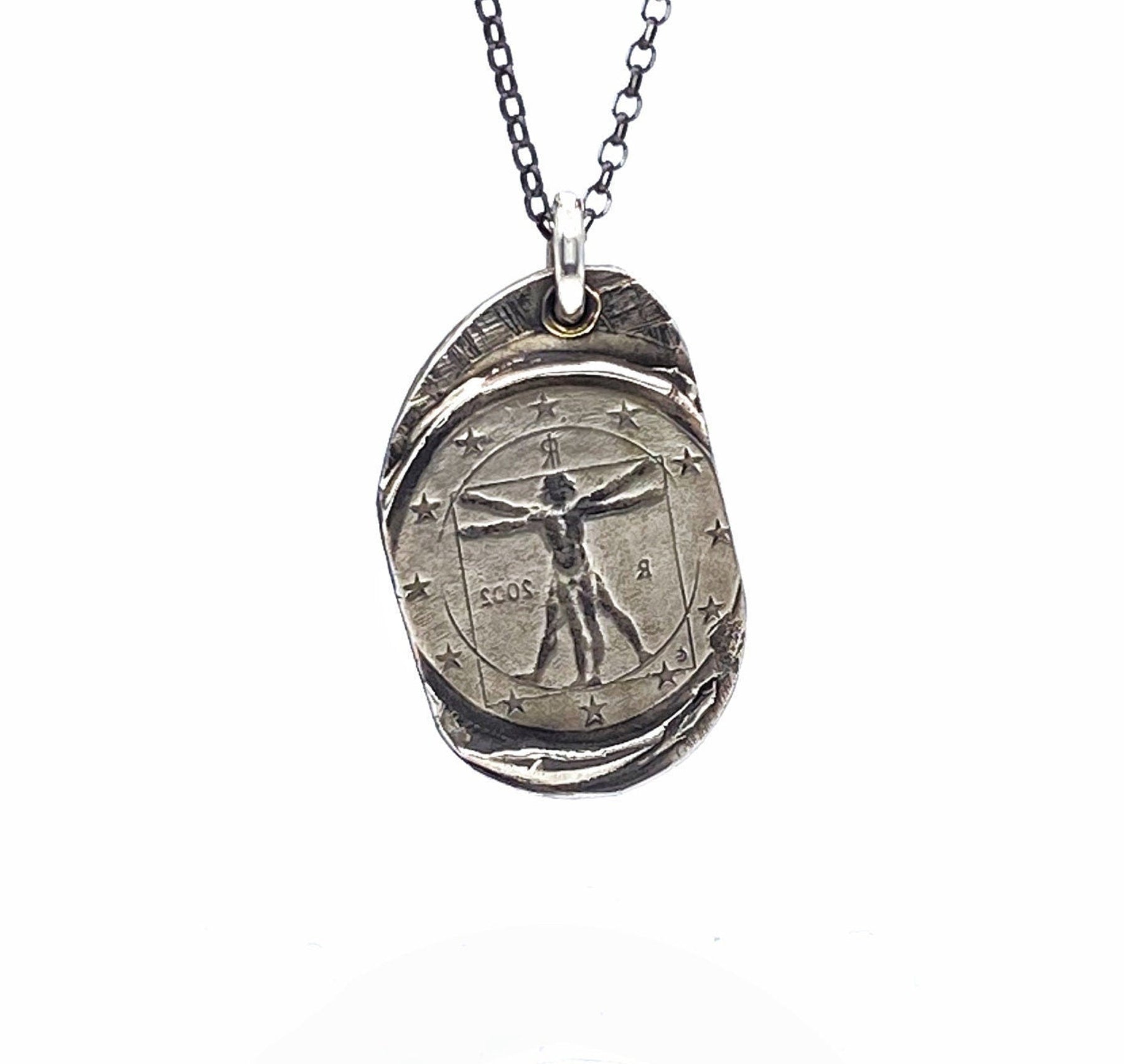 A silver necklace featuring a pendant with a design based on Leonardo Da Vinci's Vitruvian Man masterpiece, displayed against a white background.