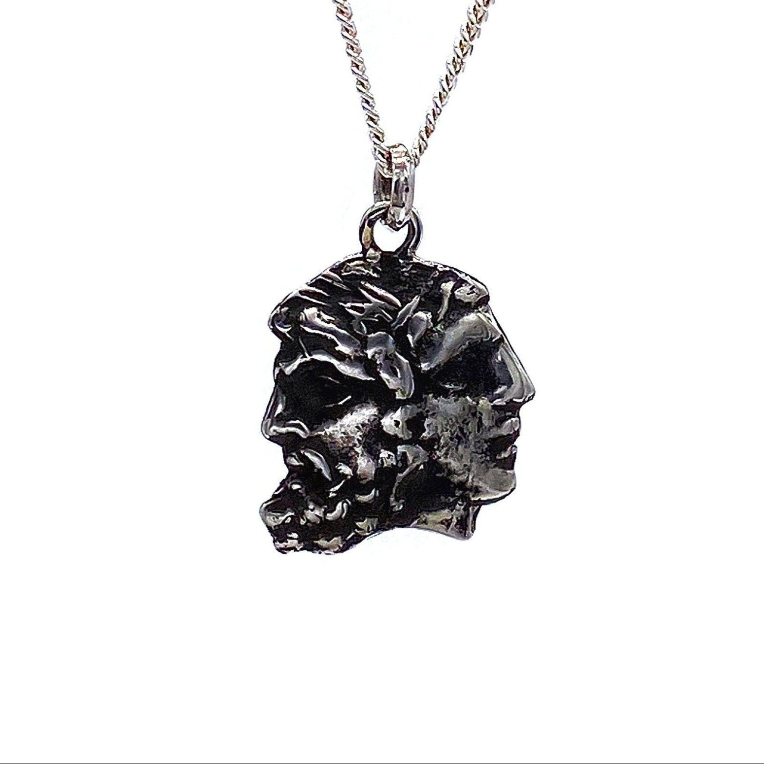 A silver necklace featuring a pendant with two faces, representing the god Janus, in a rustic finish.