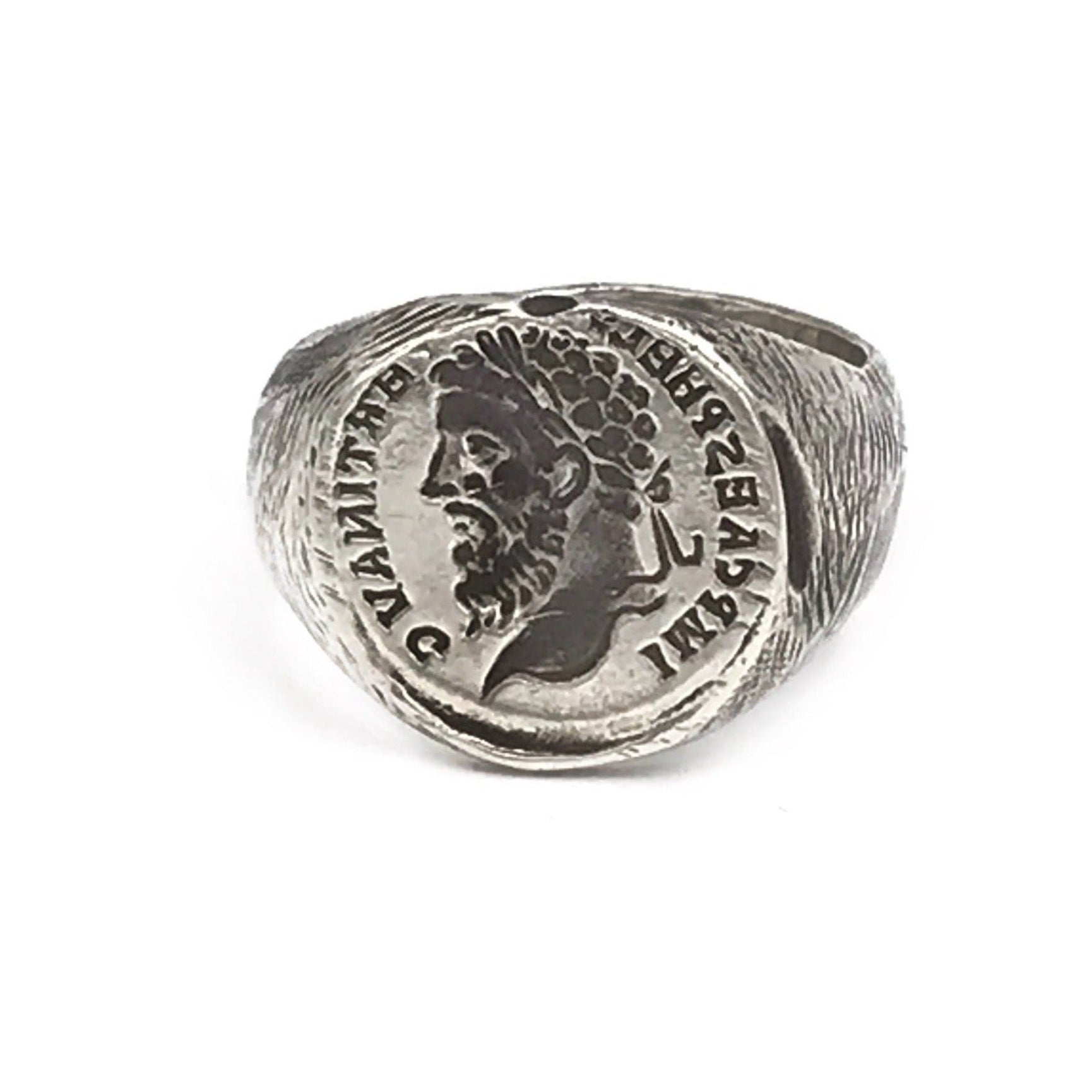 A silver signet ring featuring a ancient rustic signet design with a figure's portrait engraved on the top.