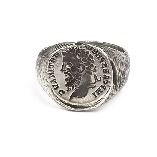 A silver signet ring featuring a ancient rustic signet design with a figure's portrait engraved on the top.