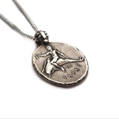 A sterling silver necklace featuring a coin pendant with a figure of Neptune riding a dolphin.