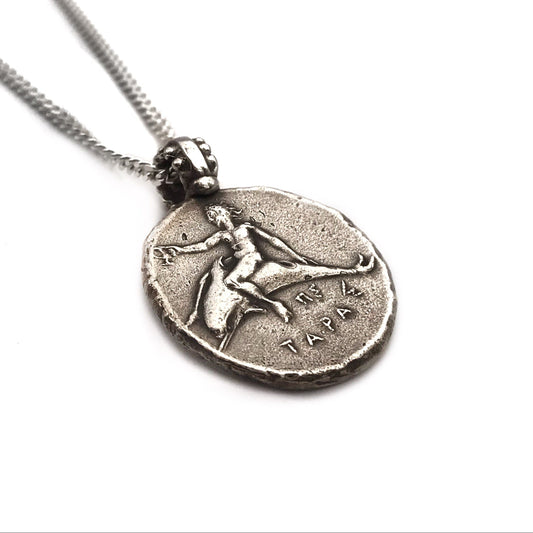 A sterling silver necklace featuring a coin pendant with a figure of Neptune riding a dolphin.