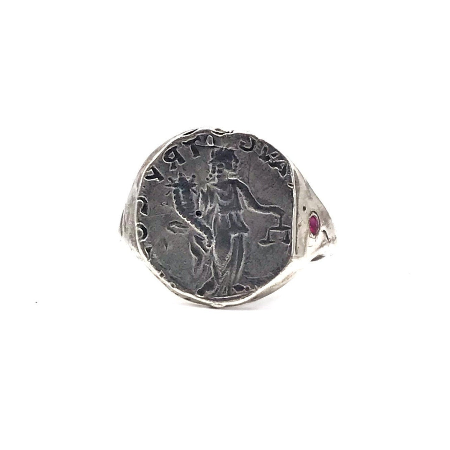A sterling silver ring with an engraved ancient coin and a red ruby stone