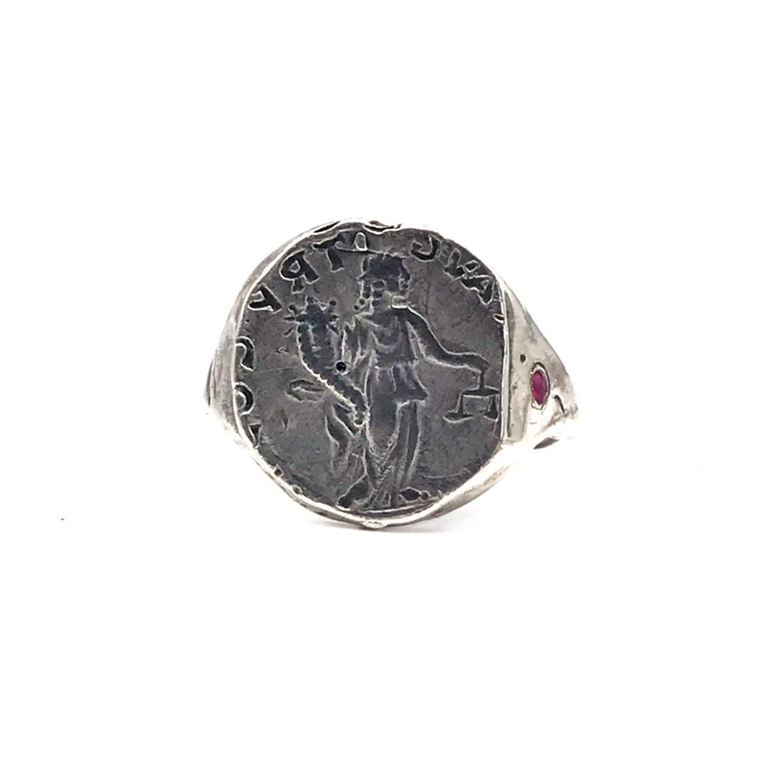 A sterling silver ring with an engraved ancient coin and a red ruby stone