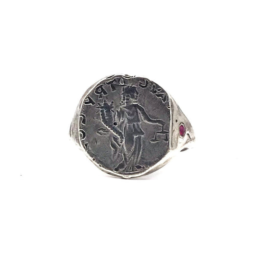 A sterling silver ring with an engraved ancient coin and a red ruby stone