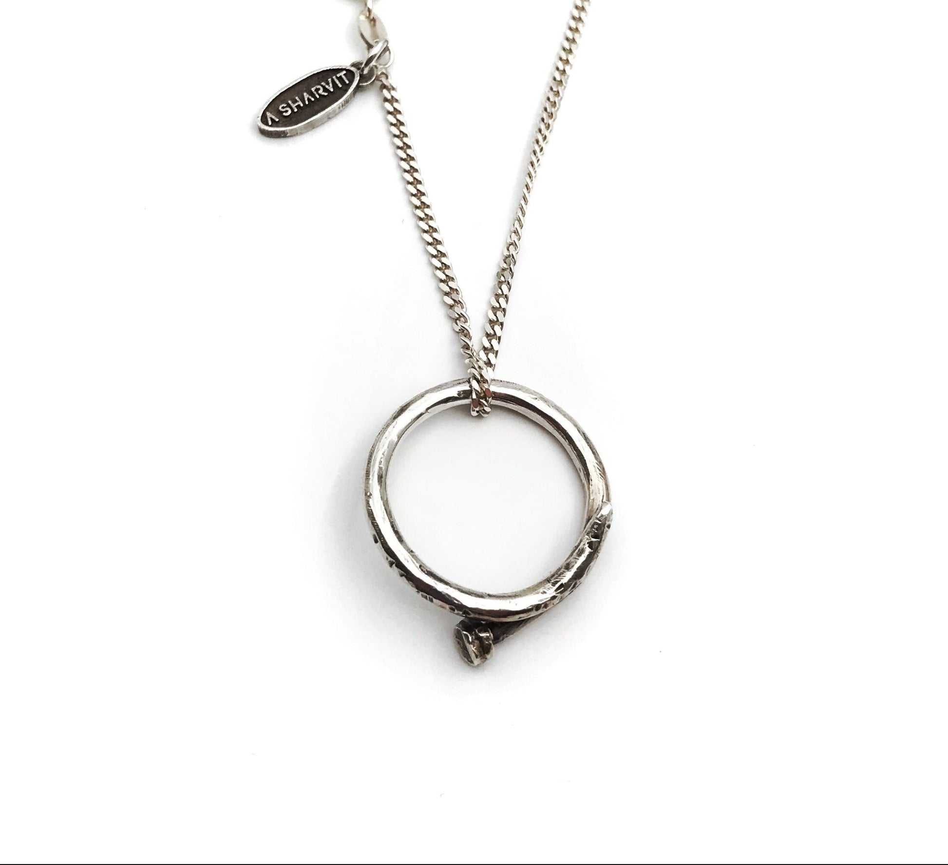 A sterling silver necklace with a handcrafted circle nail pendant, oxidized and polished for a shiny finish.
