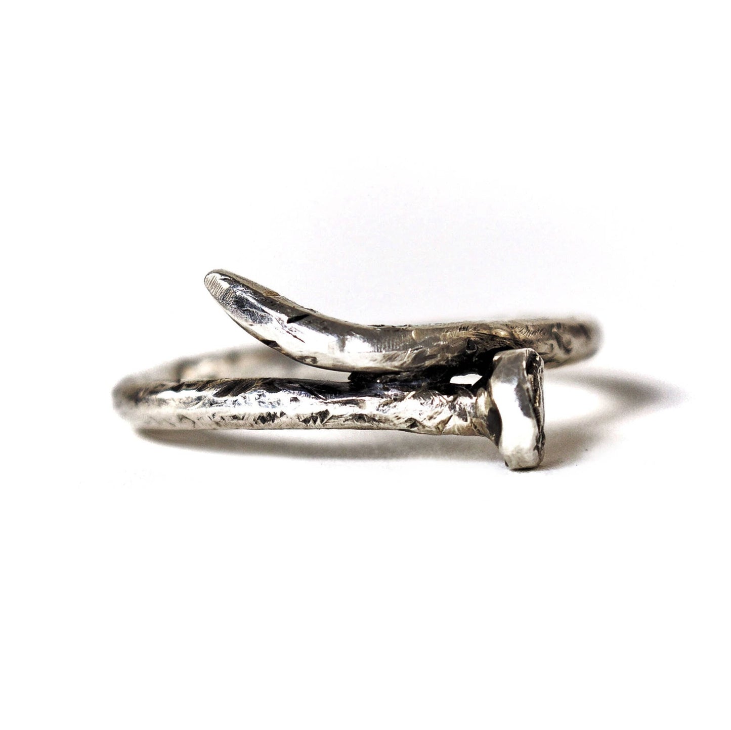 A sterling silver ring designed to resemble a rusty nail, with a realistic scratched finish.