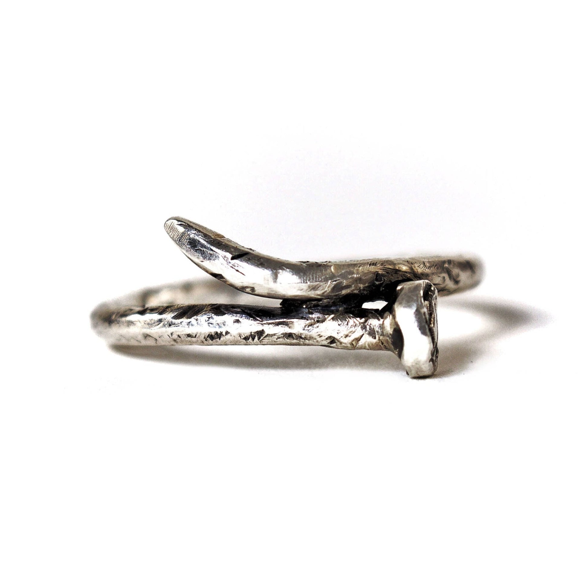 A sterling silver ring designed to resemble a rusty nail, with a realistic scratched finish.