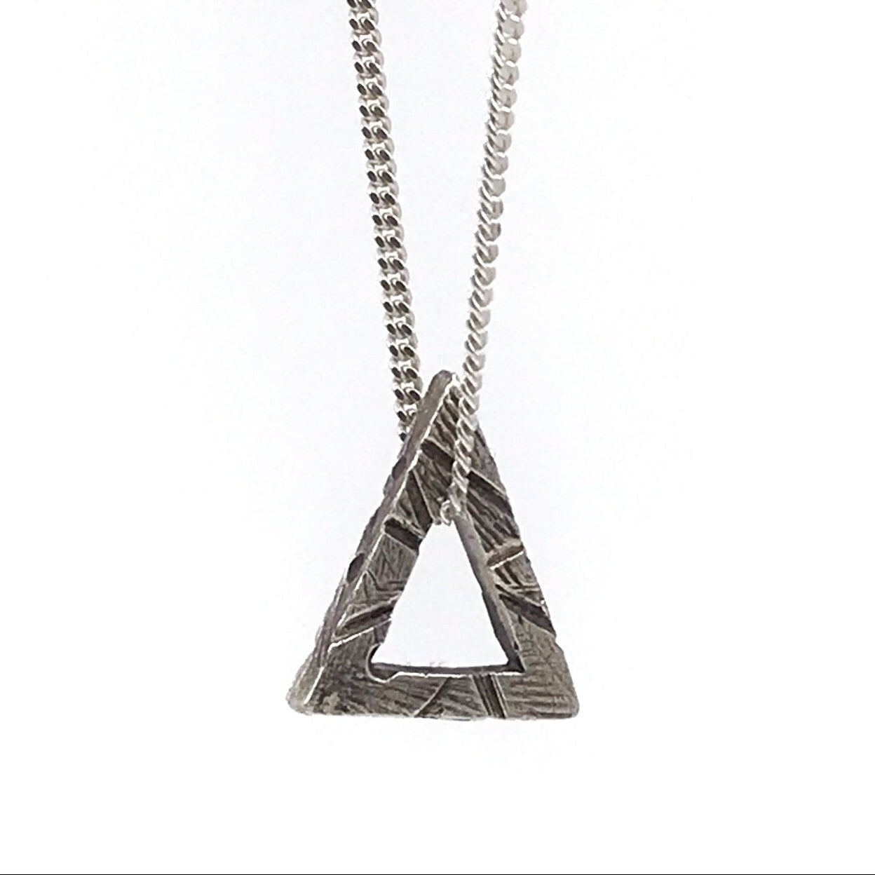 A sterling silver triangle necklace with a textured surface, attached to a chain of the same material.