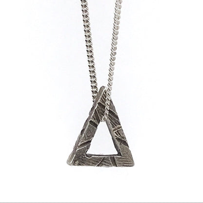 A sterling silver triangle necklace with a textured surface, attached to a chain of the same material.