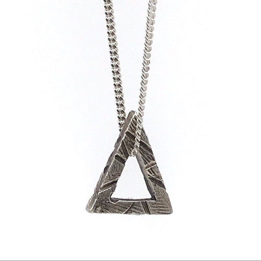 A sterling silver triangle necklace with a textured surface, attached to a chain of the same material.